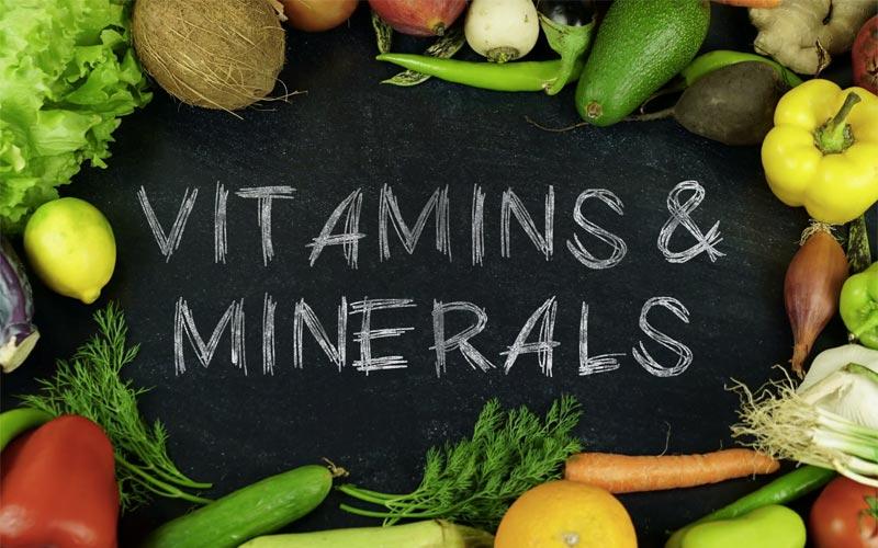 a group of fruits and vegetable around the written words vitamins and minerals