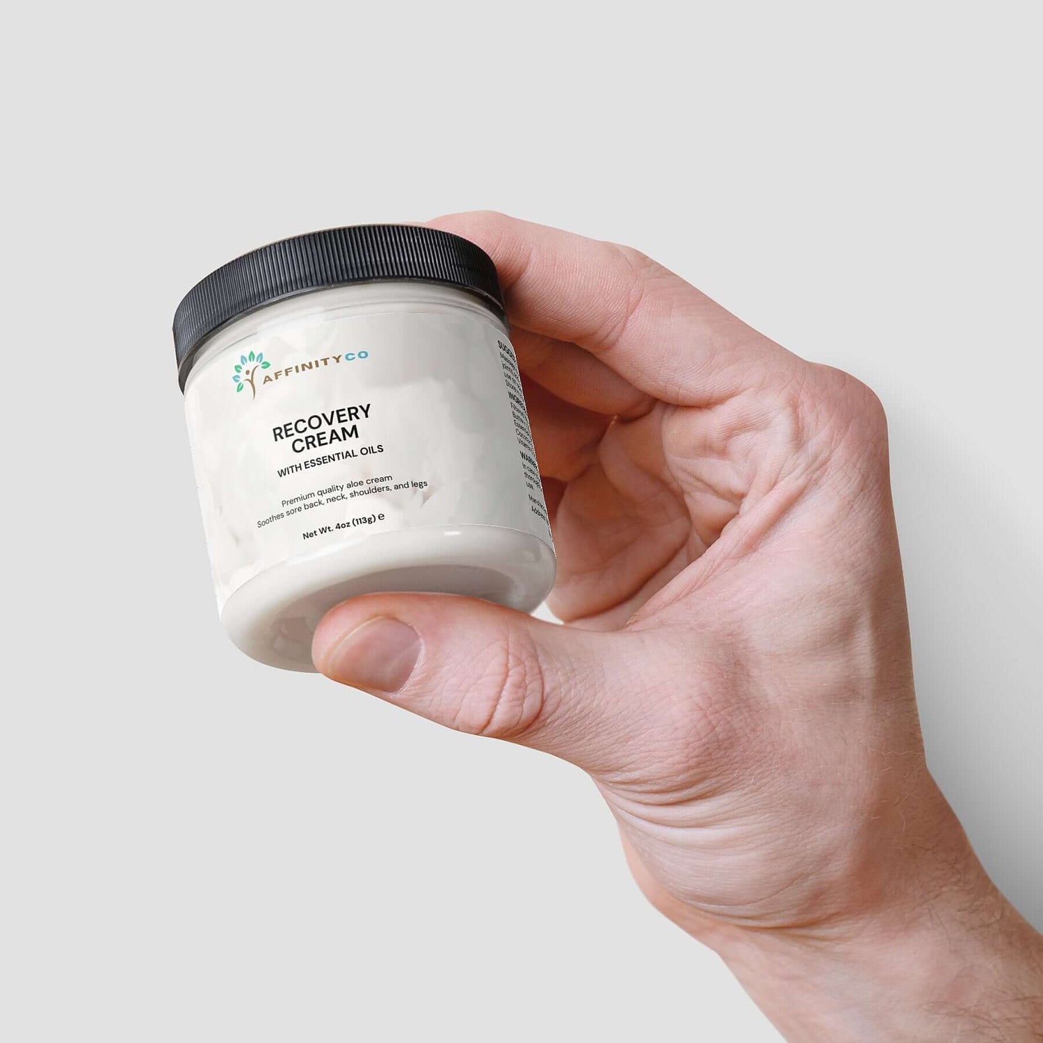 Recovery Cream jar held by one hand