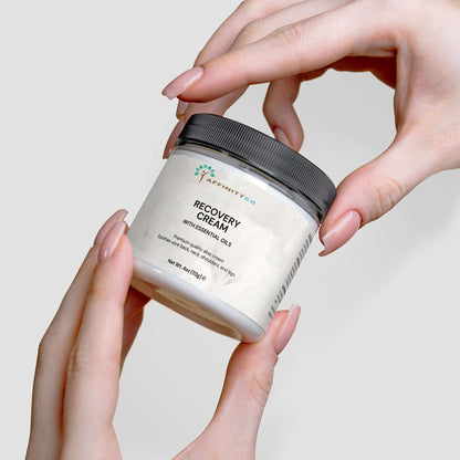 Recovery Cream held by two hands opening the jar