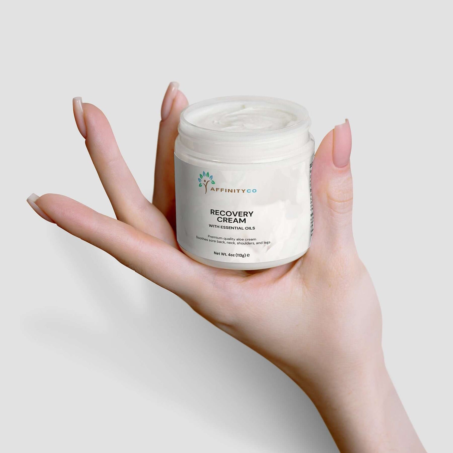 Recovery Cream held in one open hand top off